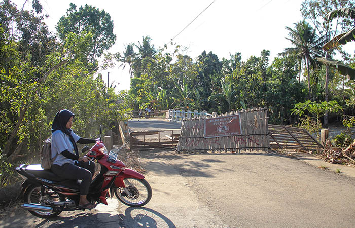 PENGHUBUNG: Warga melintas di samping Jembatan Pucunggrowong yang rusak di Kalurahan Karangtengah, Imogiri, Bantul.