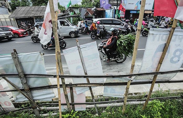 BERDERET: Pengendara kendaraan melintasi deretan Alat Peraga Kampanye (APK) di Jalan Kaliurang Km 9, Sardonoharjo, Ngaglik, Sleman kemarin (6/2). Pemkab Sleman menyiapkan langkah pengolahan sampah APK