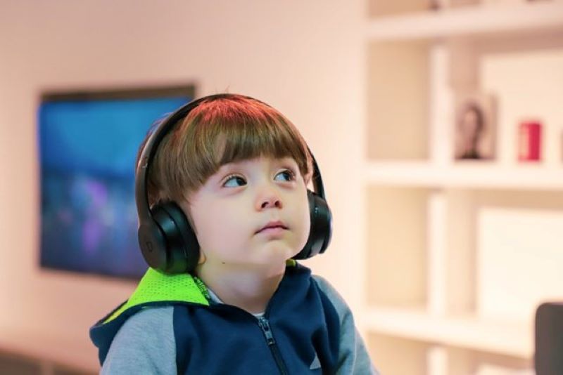 Ilustrasi seorang anak menggunakan headphone.