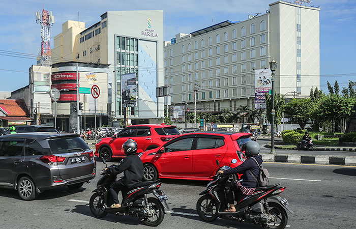TAK DIMINATI: Pengendara motor melintas berlatar bagunan hotel di kawasan simpang Condongcatur, Depok, Sleman kemarin (15/3). 