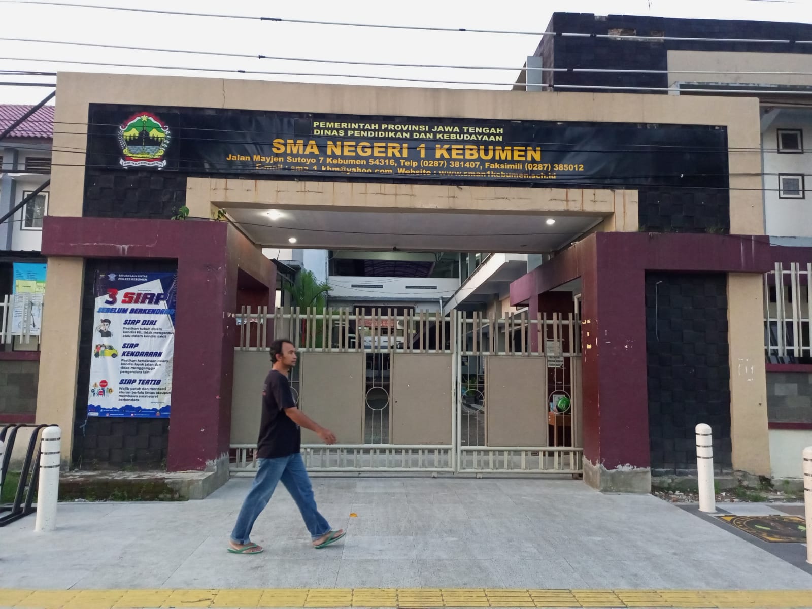 Masyarakat berjalan di depan plang SMA Negeri 1 Kebumen.
