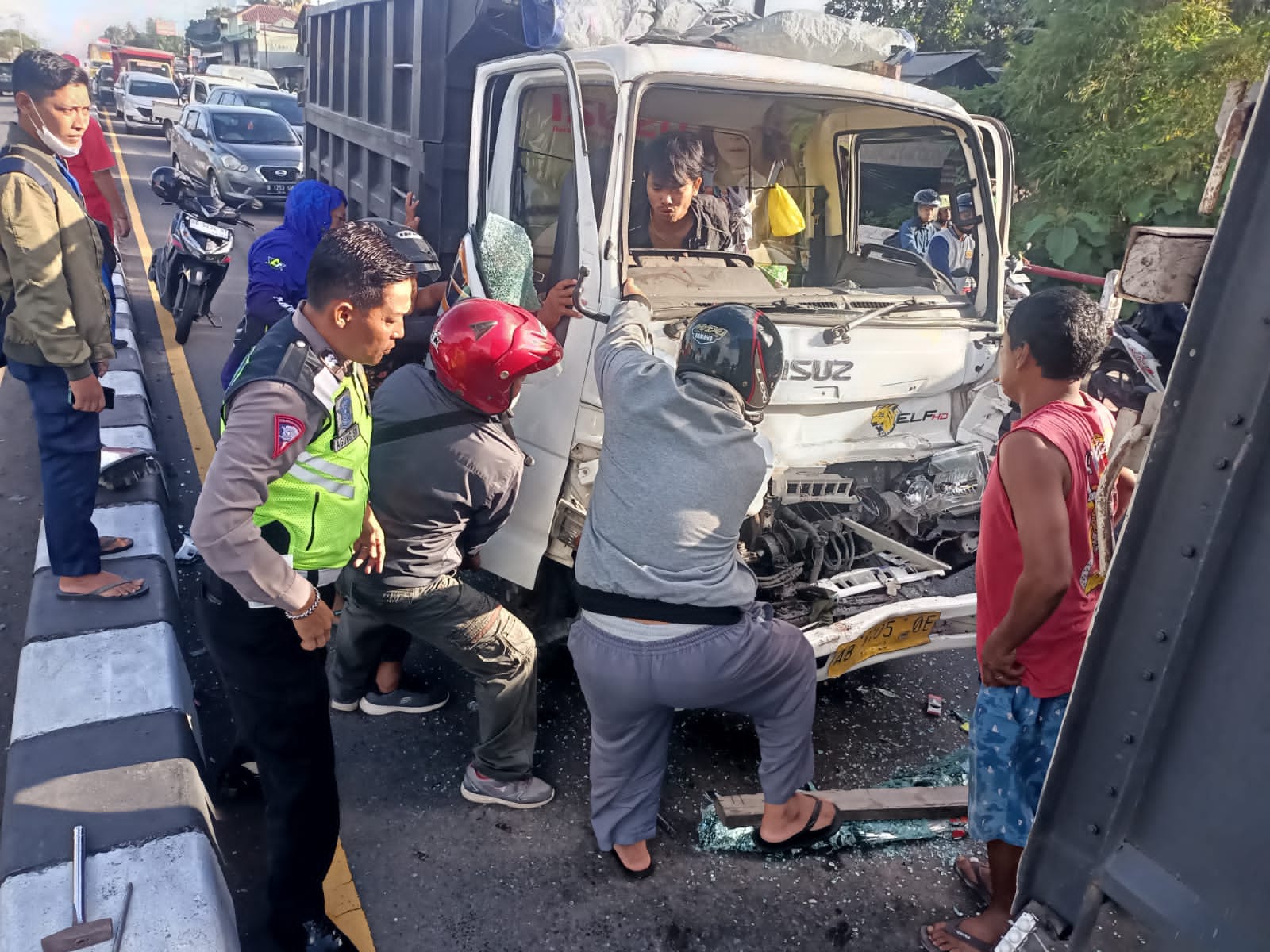 EVAKUASI: Sopir truk terjepit di kemudi dan warga berupaya untuk membantu proses evakuasi tersebut. (Dok: Ricky untuk Radar Jogja)