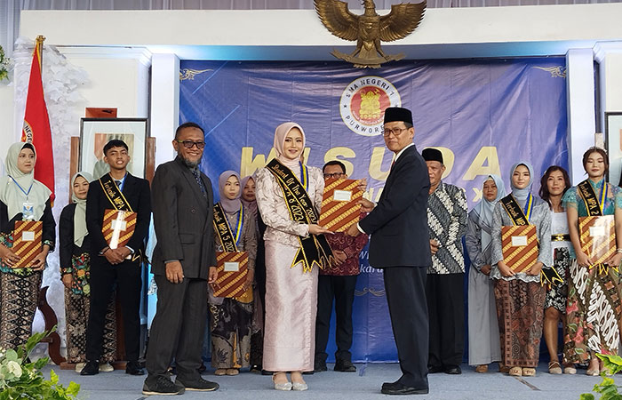 BERPRESTASI: Student of The Year SMA N 1 Purworejo Alya Kinarrahma Maharani saat menerima penghargaan dari Kepala SMA N 1 Purworejo Nur Aziz kemarin (8/5).