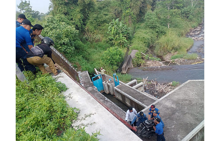 EVAKUASI: Petugas Damkar Kabupaten Magelang serta warga setempat saat berusaha menaikkan sepeda motor yang terperosok ke dasar Sungai Pabelan.