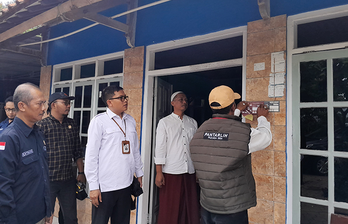 Pantarlih saat menempelkan stiker di salah satu rumah warga di Purworejo sebagai tanda rumah tersebut sudah dicoklit beberapa waktu lalu.