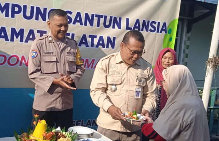 SIMBOLIS: Camat Magelah Utara saat&nbsp;menyerahkan potongan tumpeng kepada perwakilan warga RW 10 Perum Korpri Ngembik, Kramat Selatan, Sabtu (20/7).Prokompim Kota Magelang