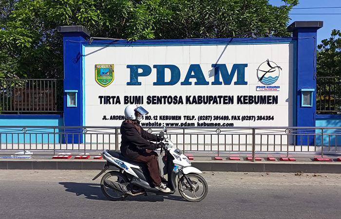 BUMD : Pengendara sepeda motor melintas di depan plang kantor PDAM Tirta Bumi Sentosa di Jalan Arungbinang, Kebumen. (M Hafied/Radar Jogja)