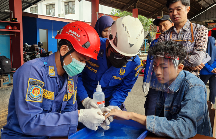 HATI-HATI: Petugas Damkar Kabupaten Magelang dengan penuh kehati-hatian melepas cincin yang melingkar di jari Arya, Kamis (1/8).NAILA NIHAYAH/RADAR JOGJA
