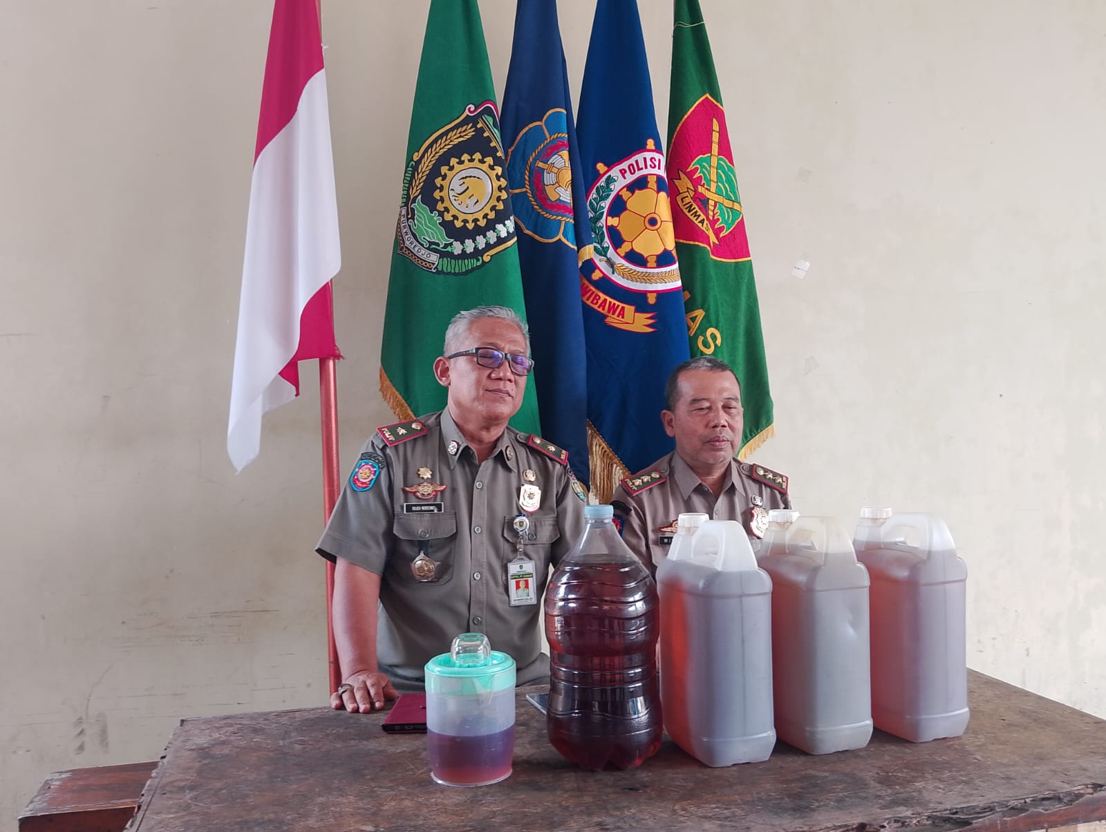 Kasatpol PP Purworejo Budi Wibowo (kiri) didampingi Kabid Penegakkan Perundang-undangan Daerah Wiworo saat menunjukkan miras hasil sitaannya pada Senin (25/11) lalu.