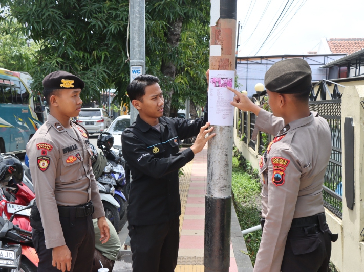 PENCARIAN : Personel Polres Kebumen memasang poster berisi identitas dan ciri fisik Harun Masiku sebagai buronan Komisi Pemberantasan Korupsi (KPK).