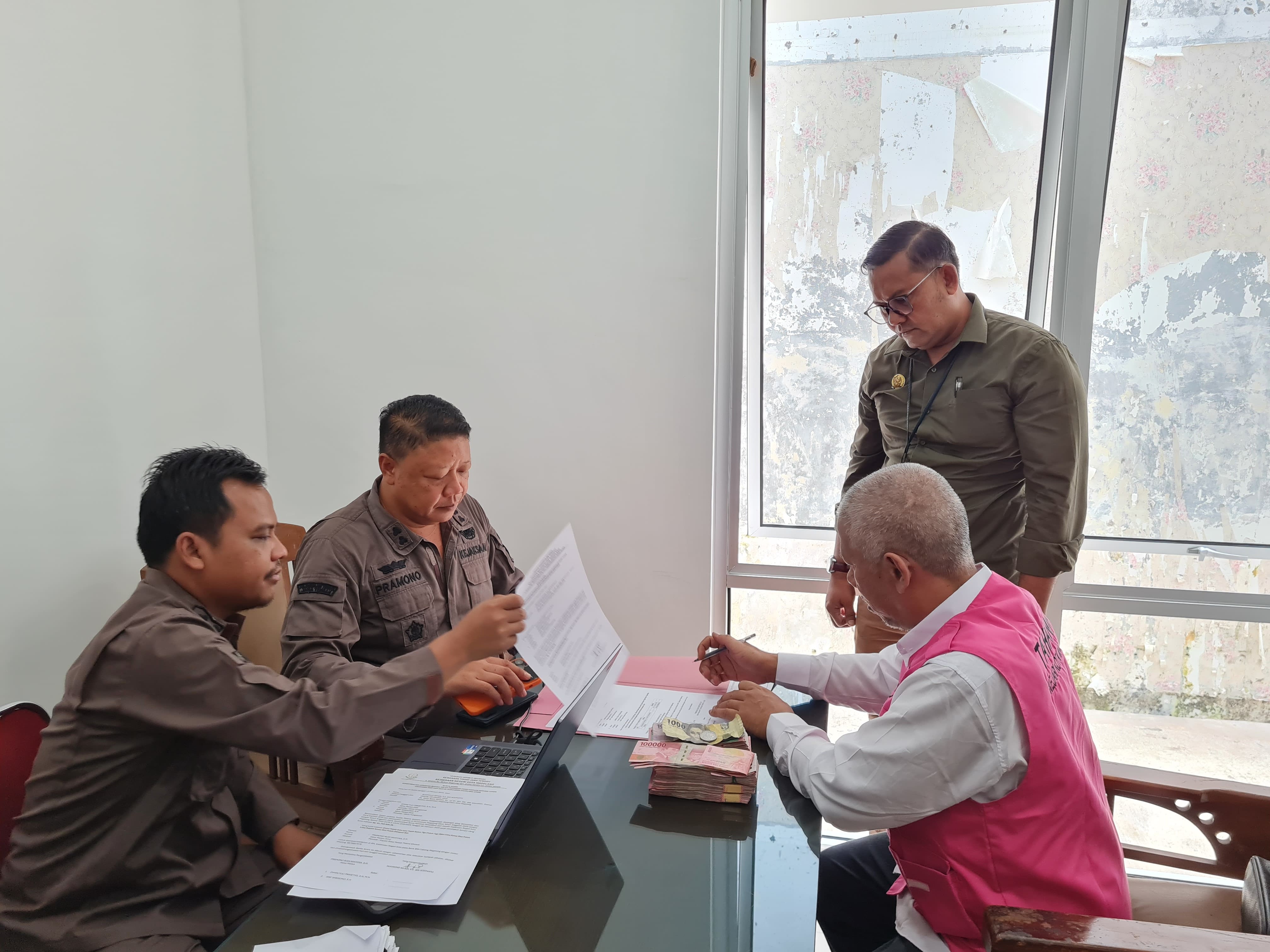 NAILA NIHAYAH/RADAR JOGJA  &nbsp;  SIMBOLIS: Tersangka NR didampingi kuasa hukumnya saat menitipkan uang pengganti kerugian negara atas kasus penyelewengan dana kapitasi kepada kejaksaan, Kamis (13/2).