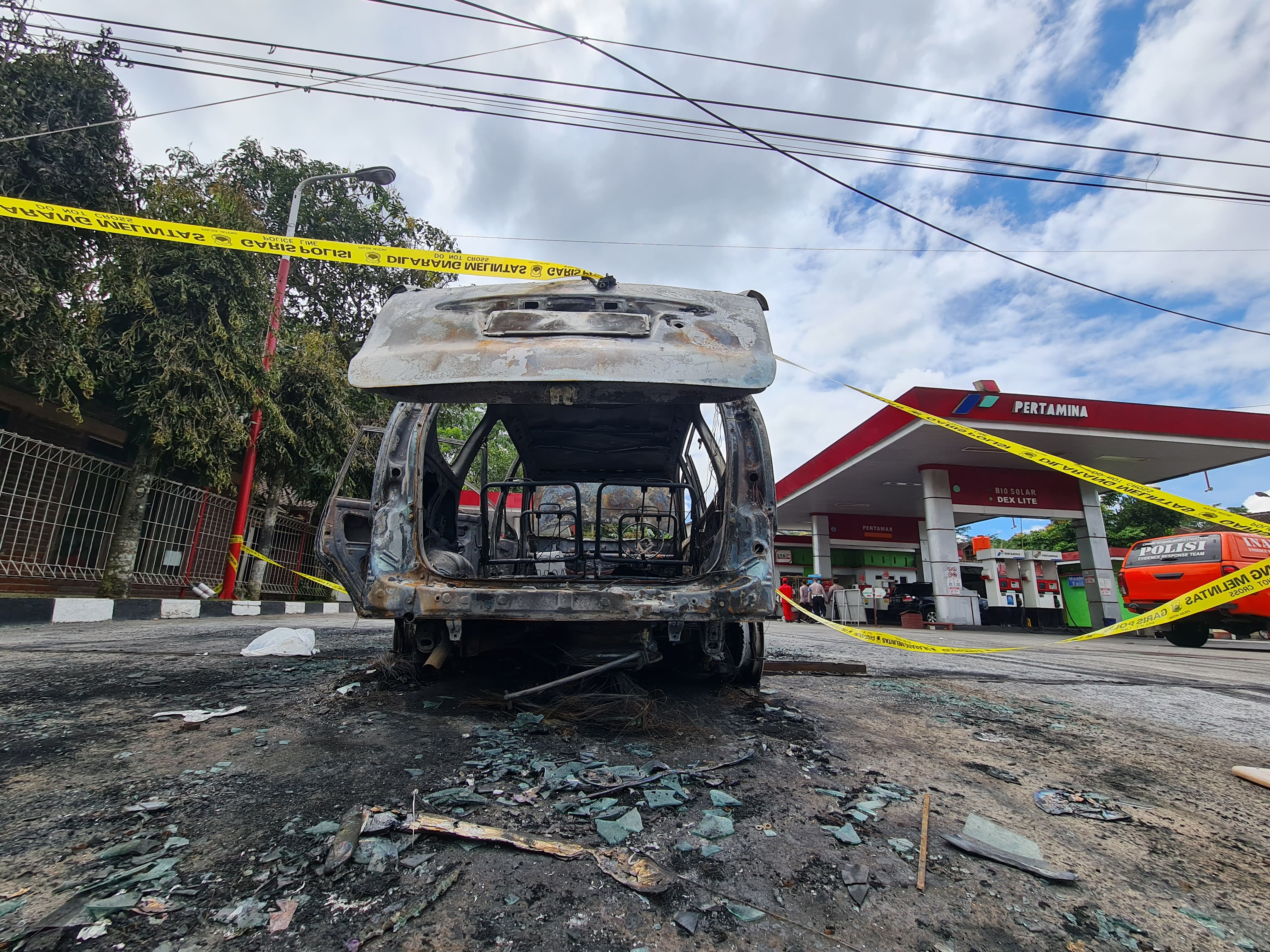 Petugas kepolisian tengah melakukan olah TKP terhadap mobil yang terbakar di SPBU Ngabean, Secang, Magelang, Kamis (24/4).