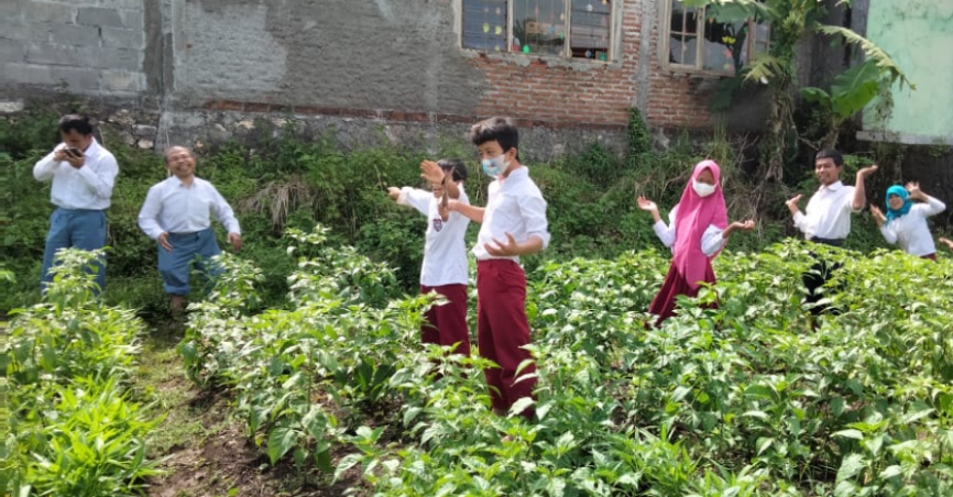 Siswa SLB Purwo Raharjo Gunungkidul sedang menunjukkan hasil panen mereka.