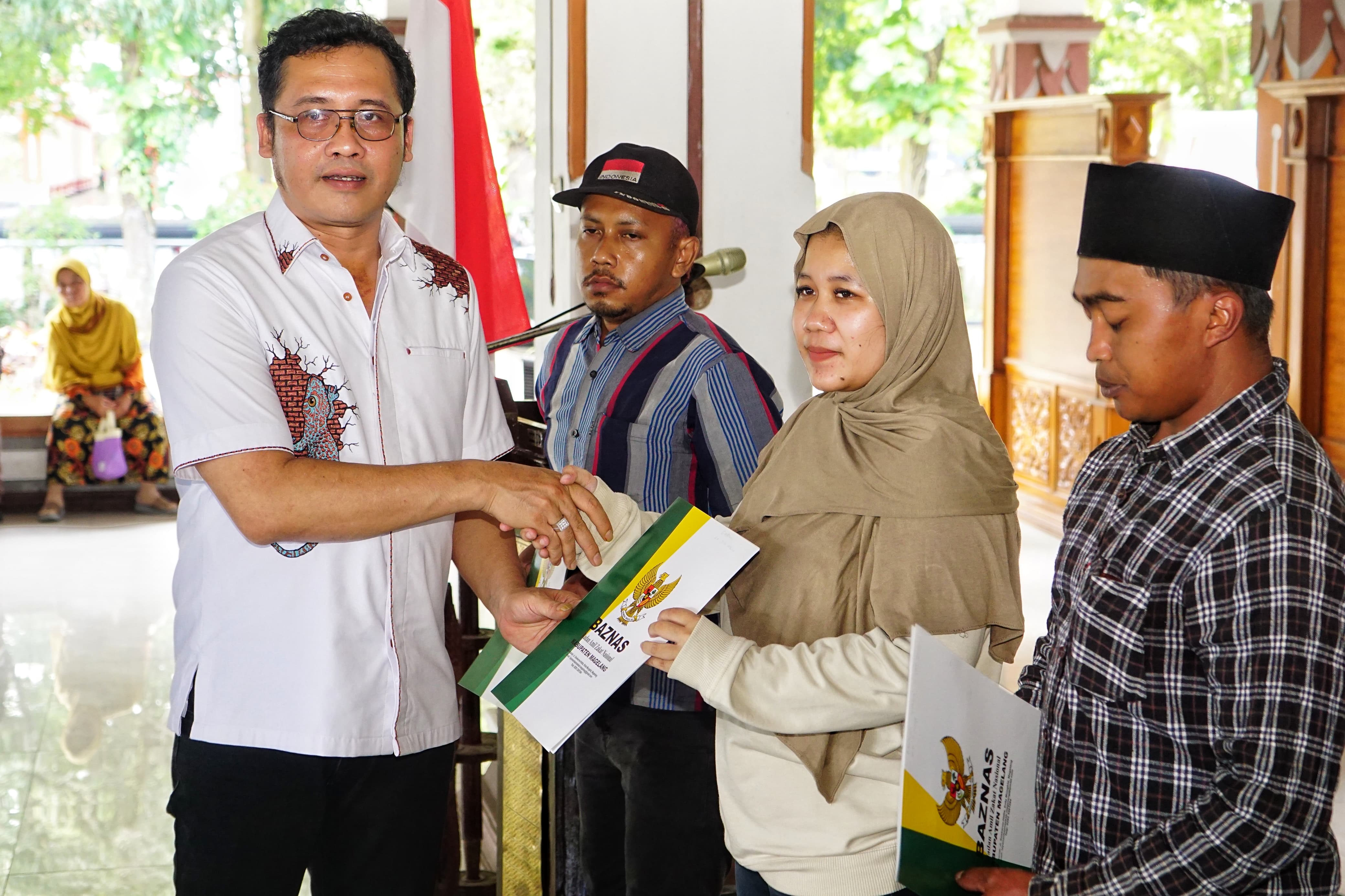Bupati Magelang menyerahkan bantuan kepada warga di Pendopo Merapi, Rumah Dinas Bupati Magelang, Kamis (4/9).