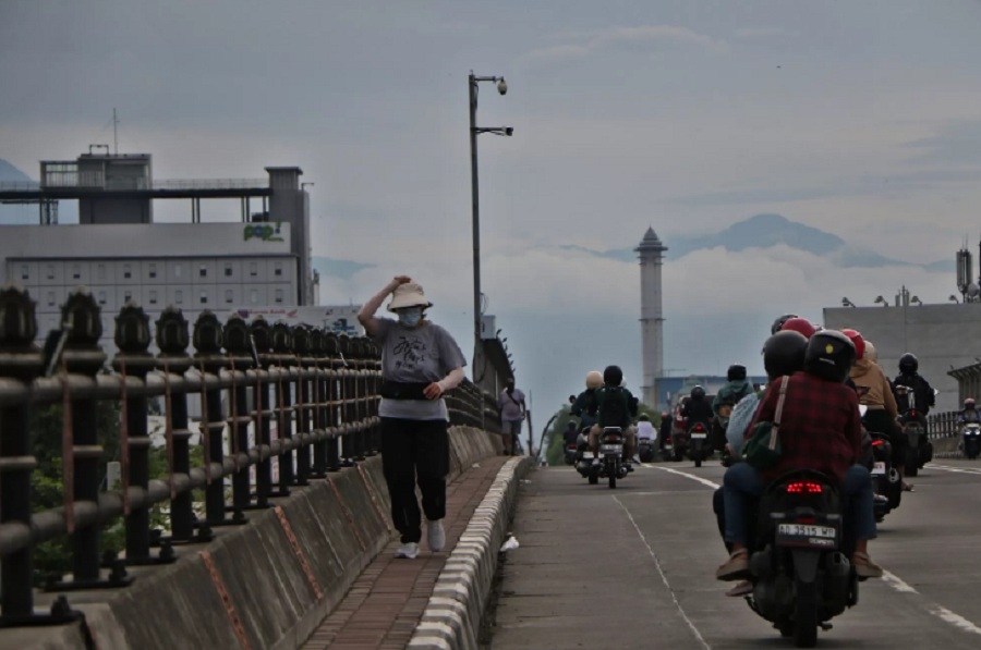 Seorang pejalan kaki sedang menikmati cuaca cerah Minggu pagi (9/11/2025).