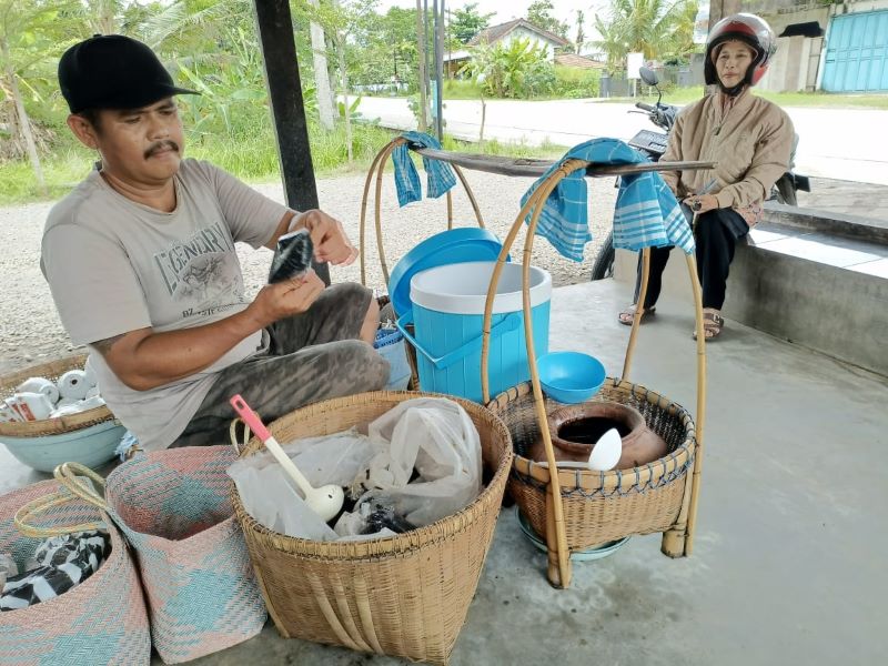 JADI JUJUKAN: Wagiman, 46, penjual es dawet hitam di seberang Jembatan Butuh sibuk melayani pelancong yang ingin mencicipi es dawet khas Purworejo Rabu (12/11).