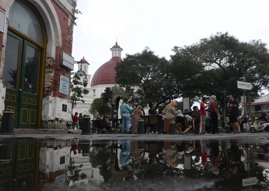 Para pelancong sedang menikmati vibes kawasan Kota Lama Semarang.