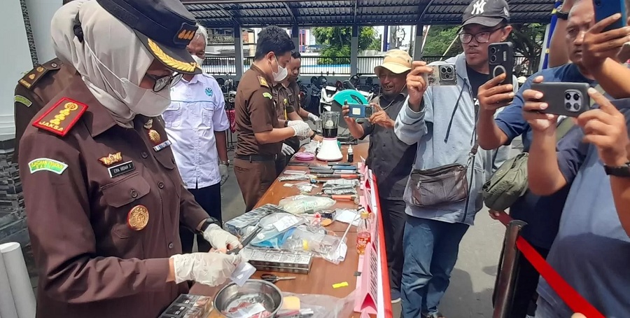 Kajari Karanganyar Era Indah Soraya (kiri) memotong tiket wisata air terjun Jumog. Total ada 45 perkara hukum inkrah yang dimusnahkan, Rabu (19/11/2025).