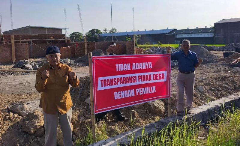 Warga pasang spanduk bernada protes di lokasi yang akan dibangun KDMP di Desa Karangduren, Kecamatan Sawit, Boyolali.