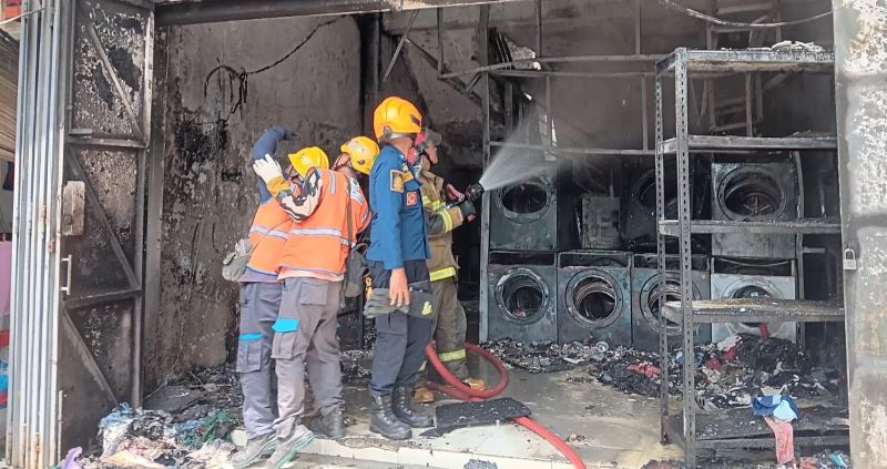 Petugas Damkar Klaten berupaya melakukan pemadaman api di ruko laundry Jalan Prenjak, Kelurahan Bareng, Kecamatan Klaten Tengah, Senin (8/12/2025).