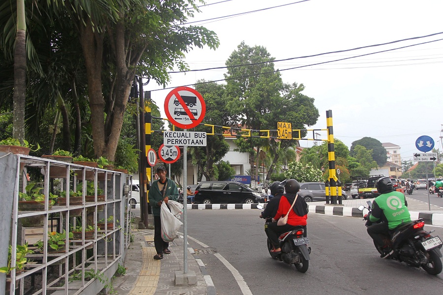 Pengguna jalan melintas di dekat portal pembatas kendaraan besar di simpang tiga barat Stadion Kridosono, Kota Jogja, Jumat (19/12/2025).