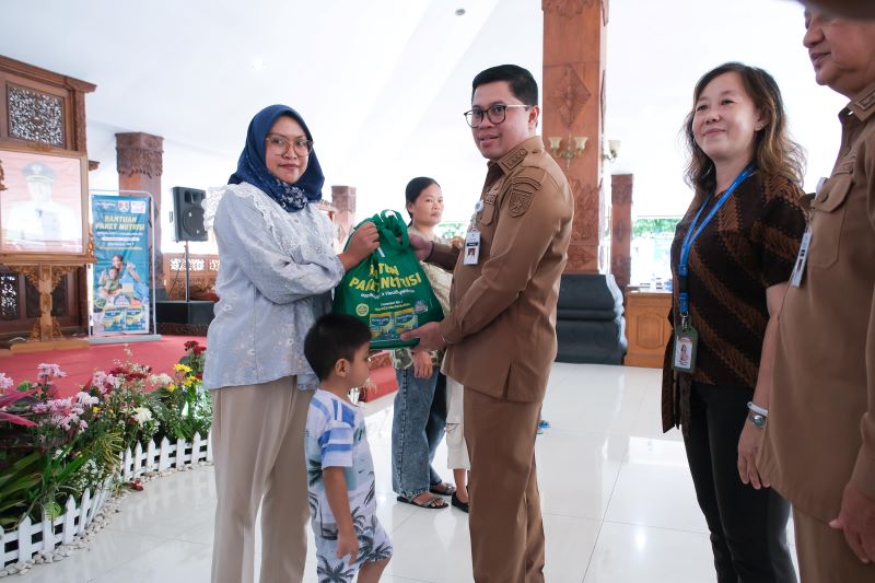 SIMBOLIS: Wali Kota Magelang saat menyalurkan bantuan paket nutrisi kepada para penerima manfaat di Pendopo Pengabdian Selasa (23/12).