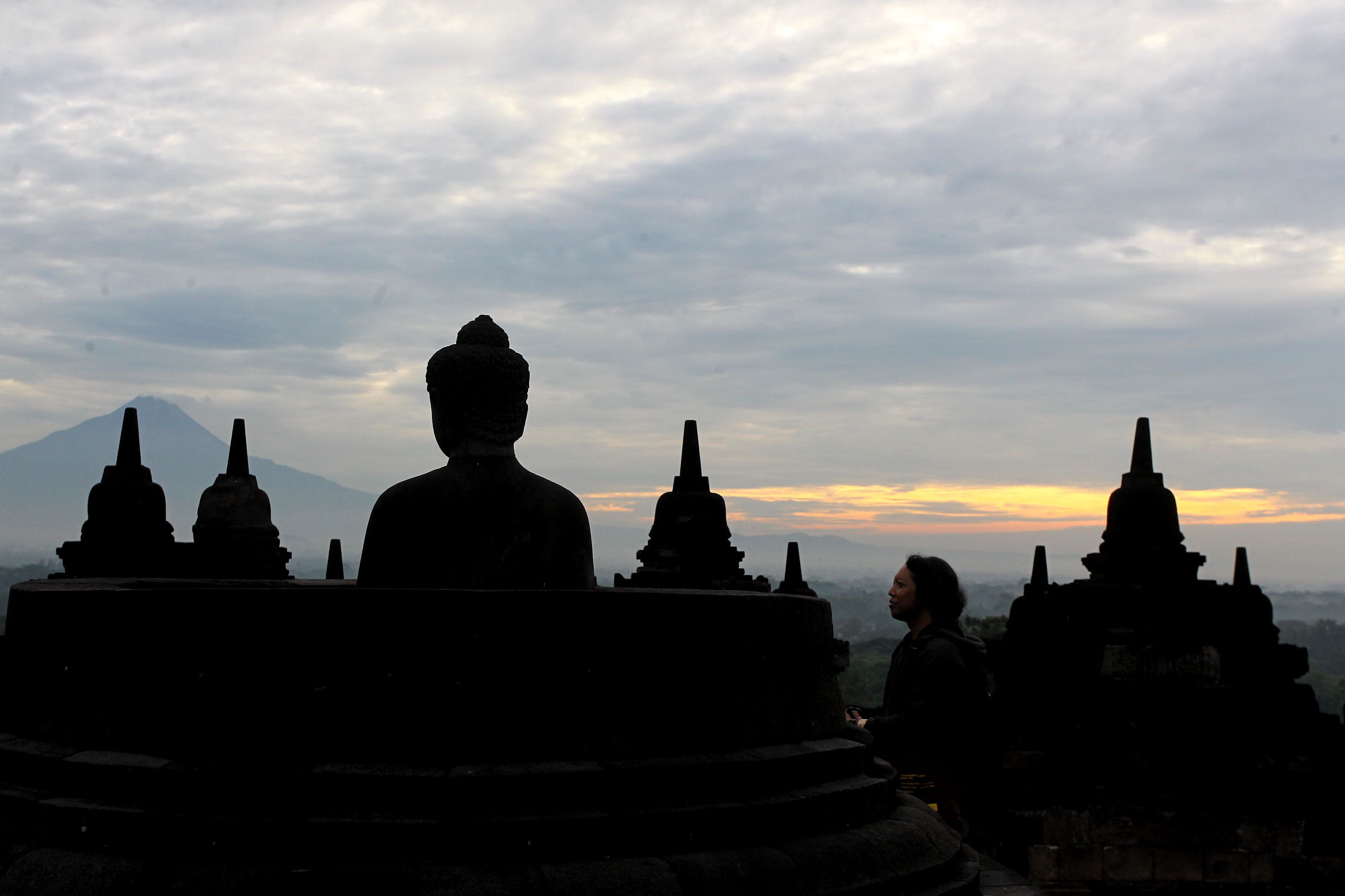 Wisatawan menyaksikan matahari terbit saat program Sunrise Borobudur di Taman Wisata Borobudur, Magelang, Jawa Tengah, kemarin (1/1). Sekitar seratus wisatawan lokal dan mancanegara berkesempatan meni