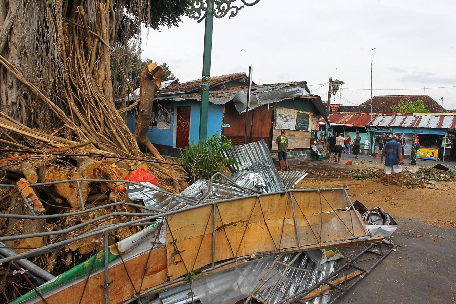 Warga membersihkan sisa-sisa pohon tumbang di kompleks Makam Raja-Raja Kotagede, Kota Jogja, Rabu  (11/2/2026).