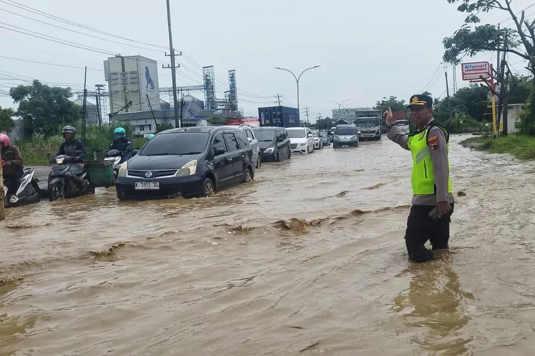 Kapolsek Genuk Kompol Rismanto terjun ke lokasi banjir mengatur arus lalulintas (Radar Semarang)