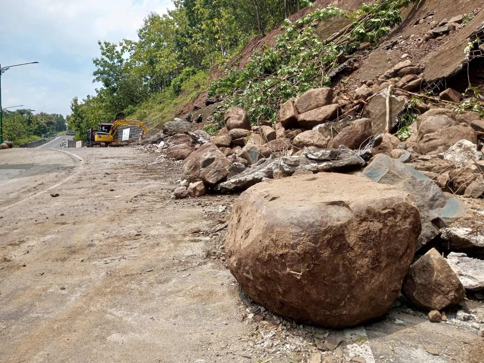 BPBD Gunungkidul mengerahkan satu alat berat dan dua dam truk untuk mempercepat mengevakuasi material longsor dari area jalan.