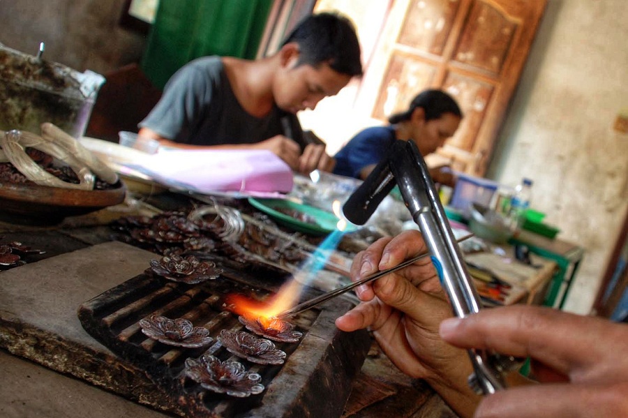 Perajin memproduksi kerajinan berbahan baku perak di salah satu sentra kerajinan perak di kawasan Kotagede, Kota Jogja, Senin (9/3/2026).