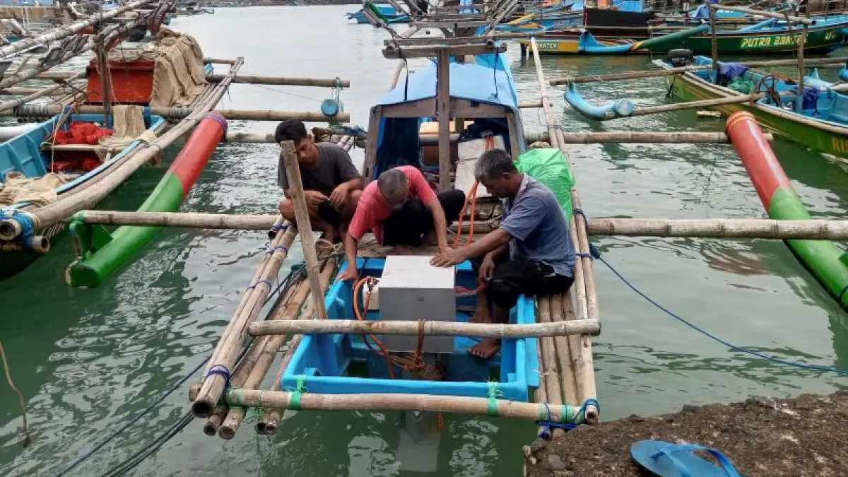 Nelayan Pantai Sadeng sedang memasang mesin listrik penggerak kapal jungkong (Yusuf Bastiar/Radar Jogja)