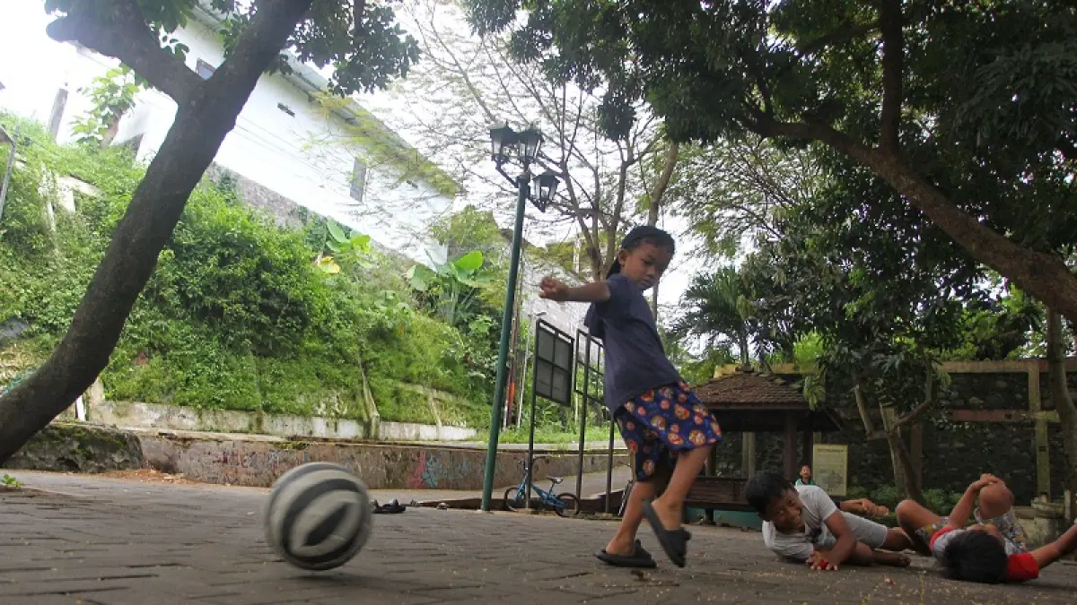 Anak-anak bermain bola saat cuaca cerah di RTH Flamboyan, Kricak, Tegalrejo, Kota Jogja, Selasa (14/4/2026). Badan Meteorologi, Klimatologi, dan Geofisika (BMKG) Yogyakarta memprediksi awal musim kemarau 2026 di wilayah DIY akan dimulai pada akhir April hingga awal Mei. Aga Tirtana/Radar Jogja.