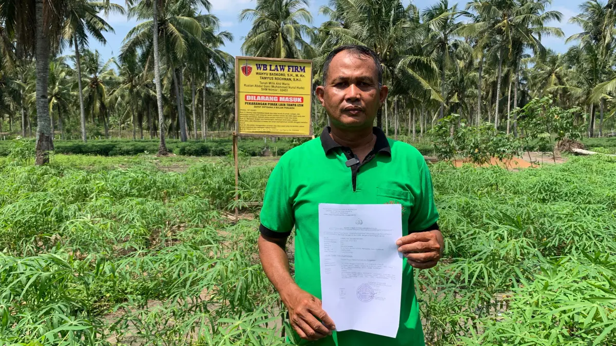 Ahmad menunjukkan laporan polisi tepat di luar tanah yang disengketakan.