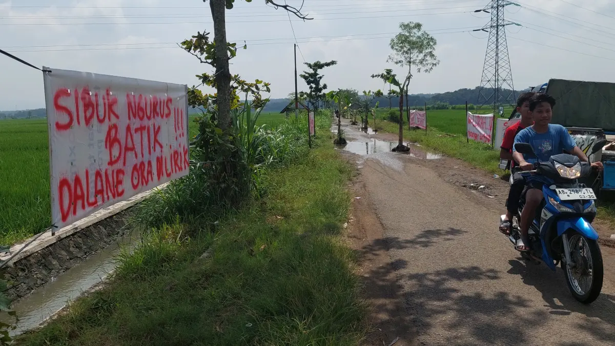 Warga memasang pohon dan banner protes terkait jalan rusak di tahun 2025 lalu.