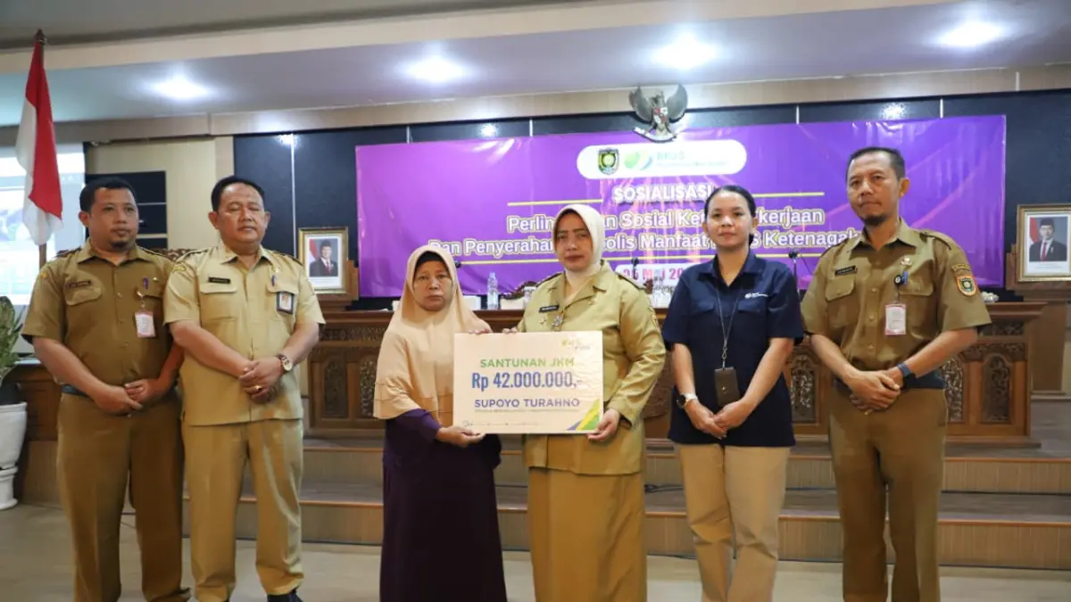 Bupati Purworejo Yuli Hastuti secara simbolis menyerahkan santunan kepada ahli waris peserta program BPJS Ketenagakerjaan. (Dokumentasi Prokopim Kebumen)