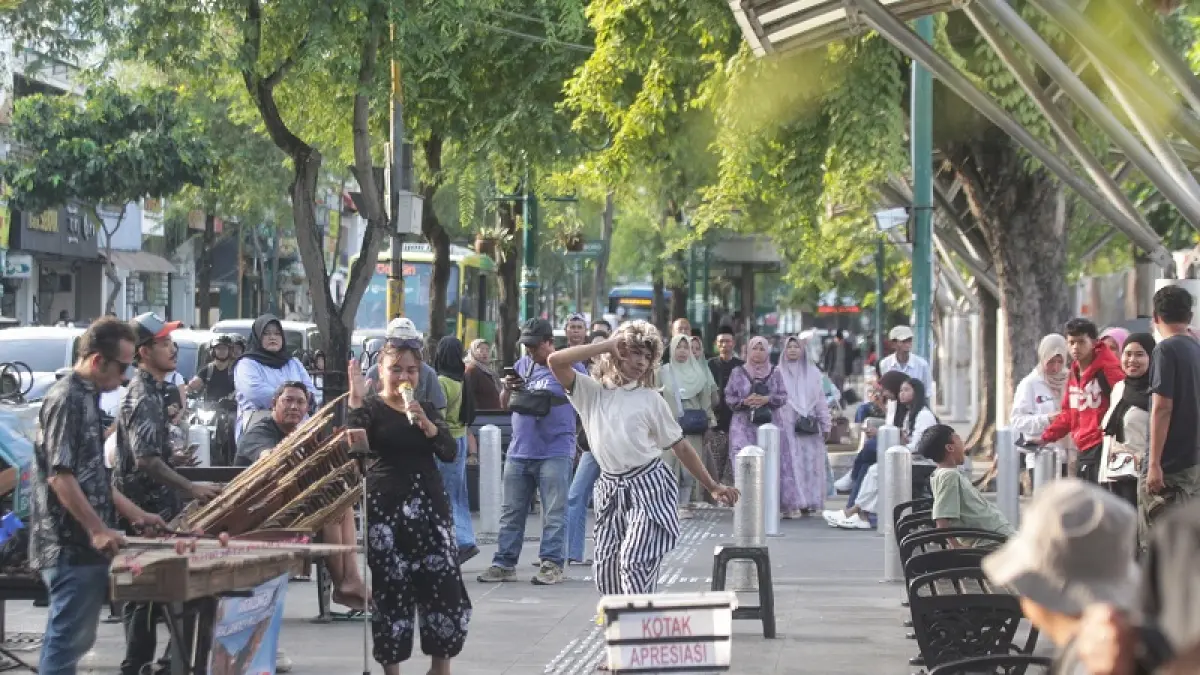 MENGHIBUR: Penari mengiringi kesenian musik angklung untuk dinikmati wisatawan yang berkunjung di kawasan Malioboro, Kota Jogja, Senin (29/6/2026). GUNTUR AGA TIRTANA/RADAR JOGJA

‎