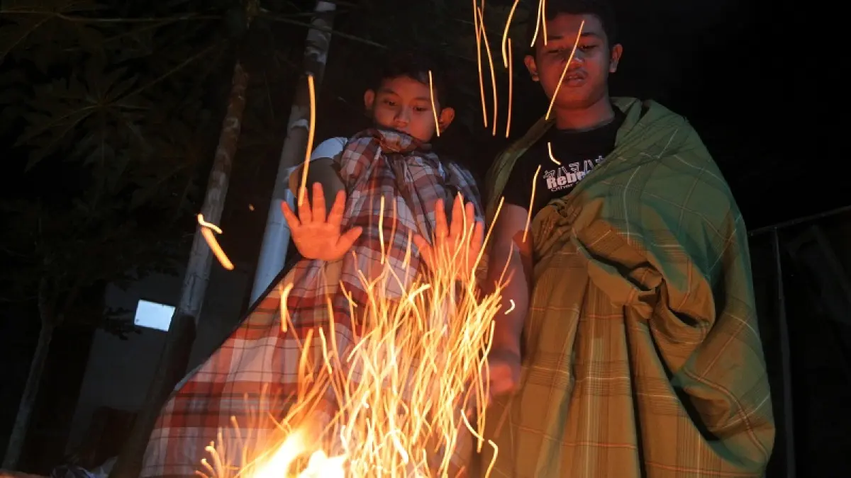 WASPADA: Bocah menyalakan api untuk menghangatkan tubuh saat cuaca&nbsp;dingin, di kawasan Pandowoharjo, Sleman, Kamis malam (2/7/2026). GUNTUR AGA TIRTANA/RADAR JOGJA
