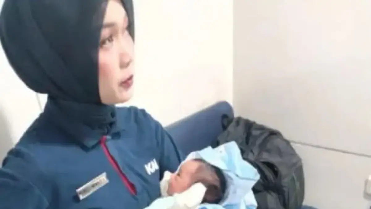 Petugas KAI menggendong bayi yang ditemukan di toilet kereta eksekutif 3 KA Sancaka&nbsp;
(Instagram/jalur5)