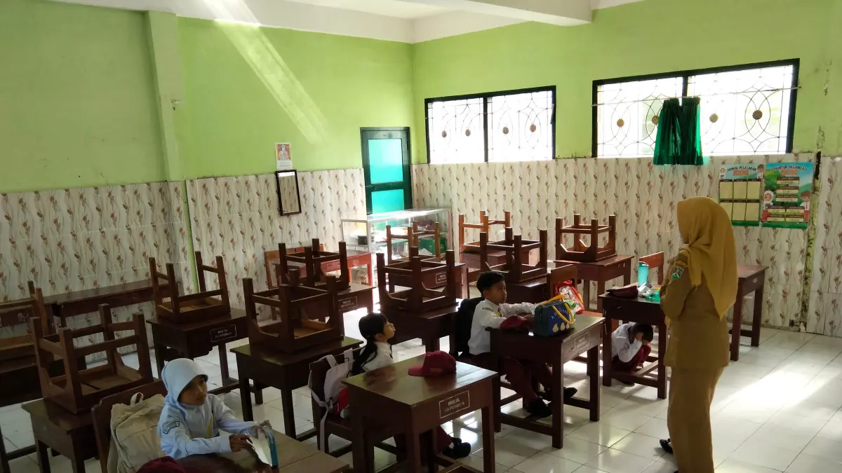 Meski hanya mendapat empat siswa, guru tetap melangsungkan kegiatan belajar mengajar di kelas, Senin (13/7).