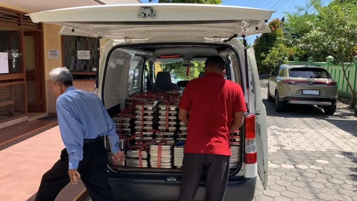 DISTRIBUSI: Petugas SPPG mengangkut ompreng dari sekolah ke mobil penjemputan. (ANOM BAGASKORO/RADAR PURWOREJO)