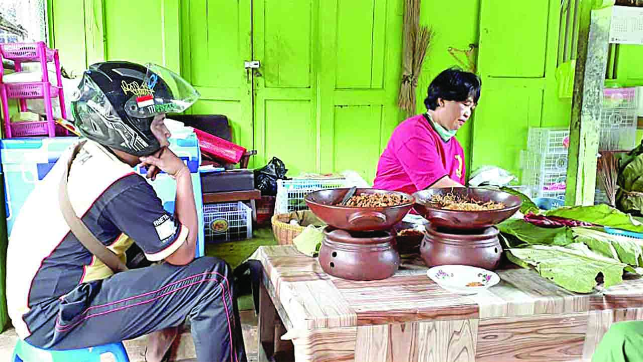 Sri Suyatmi, 60, penjual nasi brekat warga Padukuhan Tawarsari, Wonosari, sedang melayani pembeli.