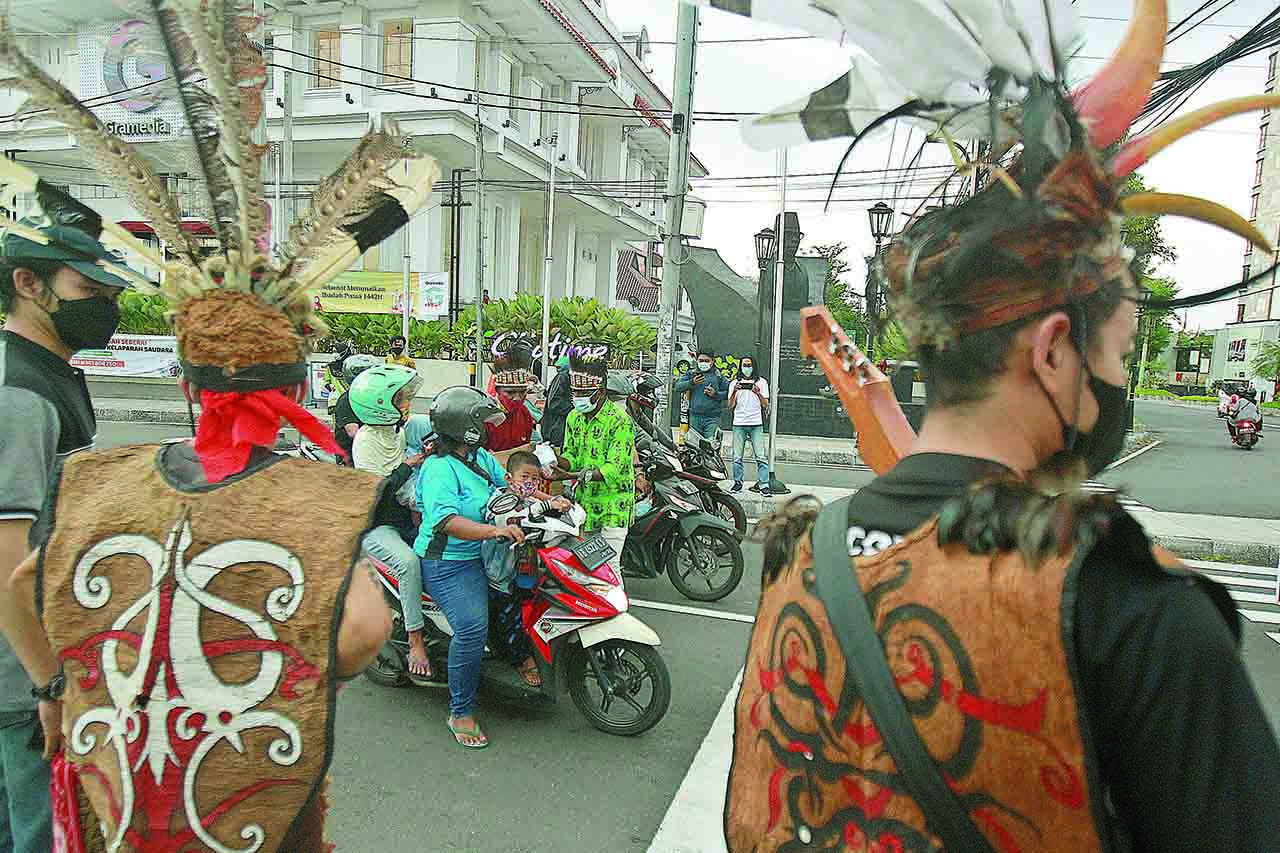 Aliansi Mahasiswa Nusantara menampilkan tarian khas Suku Dayak di sela ngabuburit di Simpang Empat Jalan Jenderal Sudirman, Jogja, Minggu (18/4).