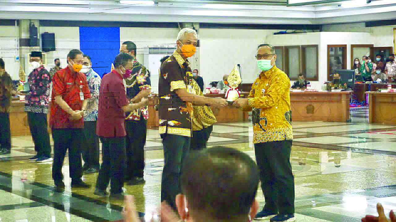 Wali Kota Magelang dr Muchamad Nur Aziz (kanan) saat menerima penghargaan predikat terbaik III Pembangunan Daerah untuk kategori Kota se Provinsi Jawa Tengah dari Gubernur Ganjar Pranowo di Gedung Gradhika Bhakti Praja Kantor Gubernur Jawa Tengah, Rabu (1