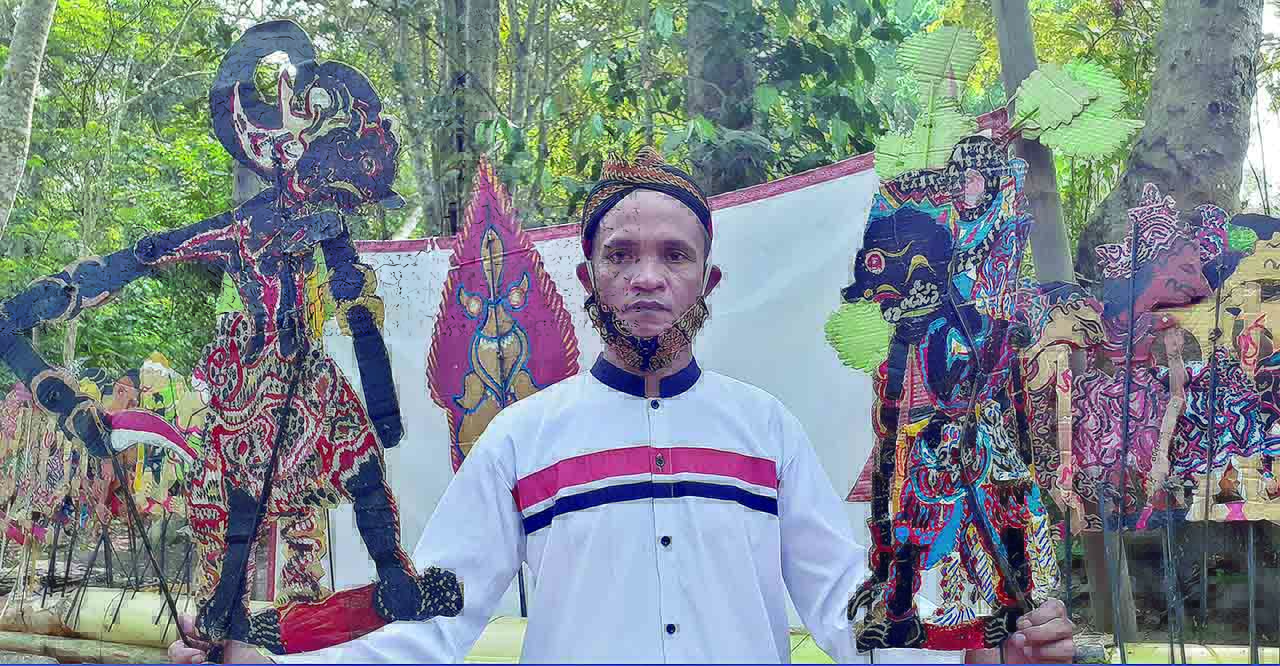 Sugiyanto menunjukkan tokoh Werkudoro alias Brontoseno dan anaknya, Gatotkaca. Wayang itu hasil buatannya dari limbah kardus.