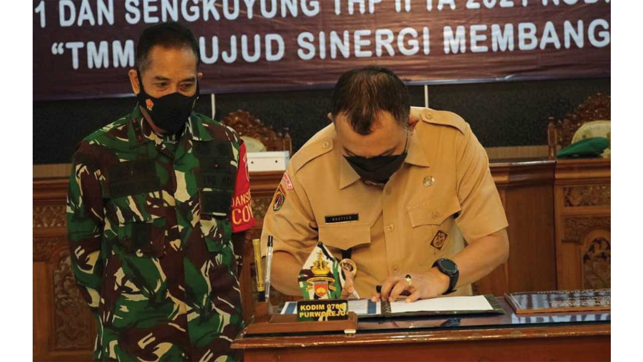 TUNTAS: Komandan Kodim 0708 Purworejo Letkol Infanteri Lukman Hakim menyerahkan hasil program TMMD Sengkuyung II kepada Bupati Purworejo Agus Bastian di Ruang Arahiwang Kompleks Setda Purworejo kemarin (14/7). (Hendri utomo/radar purworejo)