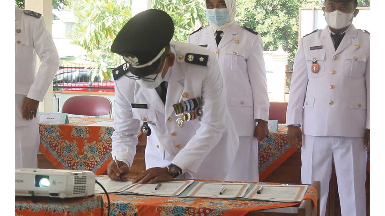 AMANAH: Suhadi menandatangani berkas pelantikan sebagai kepala desa. (HENDRI UTOMO/Radar Purworejo)