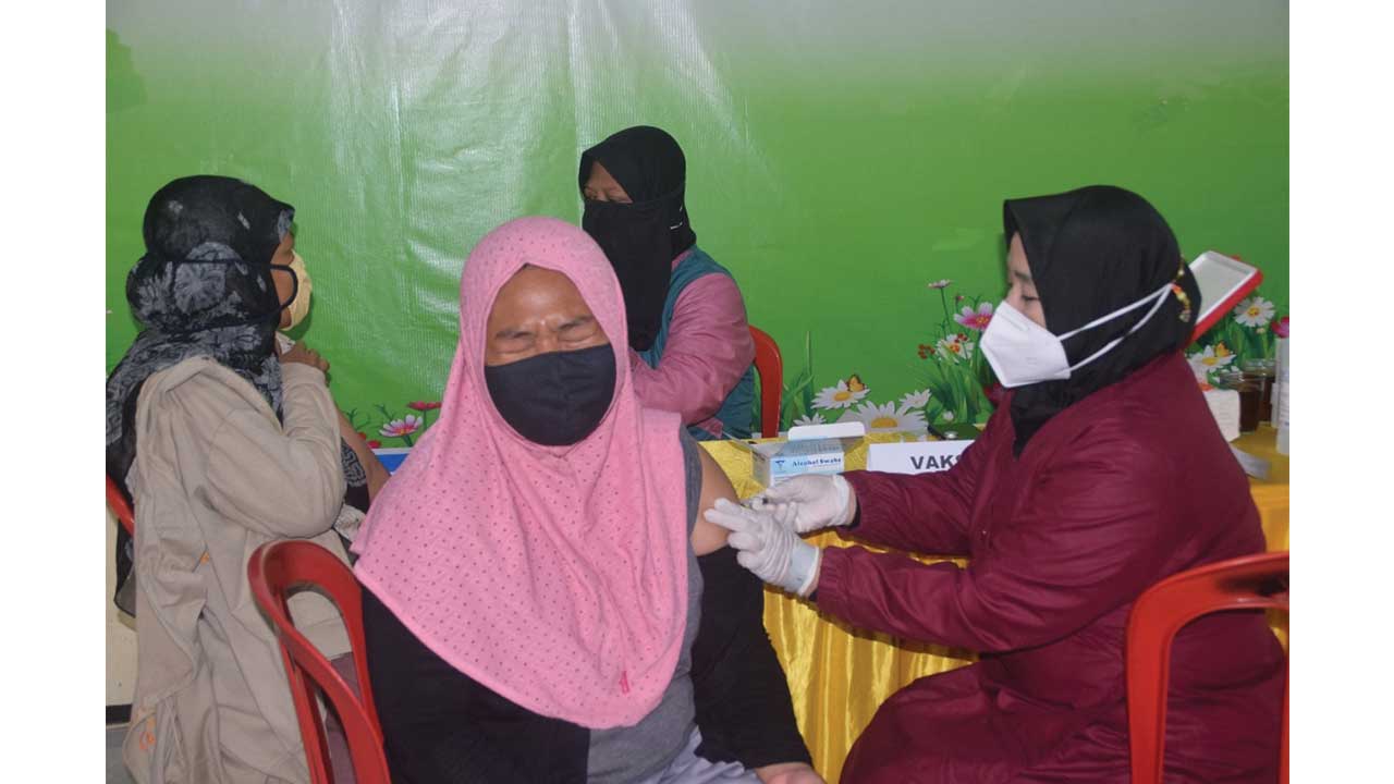 TAHAN: Seorang warga menjalani vaksinasi di Desa Dukuhrejo, Kecamatan Bayan, Kabupaten Purworejo, kemarin (20/08). (HENDRI UTOMO/RADAR PURWOREJO)