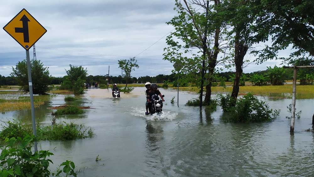 BALIK KANAN: Banjir menggenangi akses jalan menuju Desa Krandegan, Kecamatan Bayan, menghambat akses warga keluar dan masuk ke desanya, kemarin. (HENDRI UTOMO/RADAR PURWOREJO)