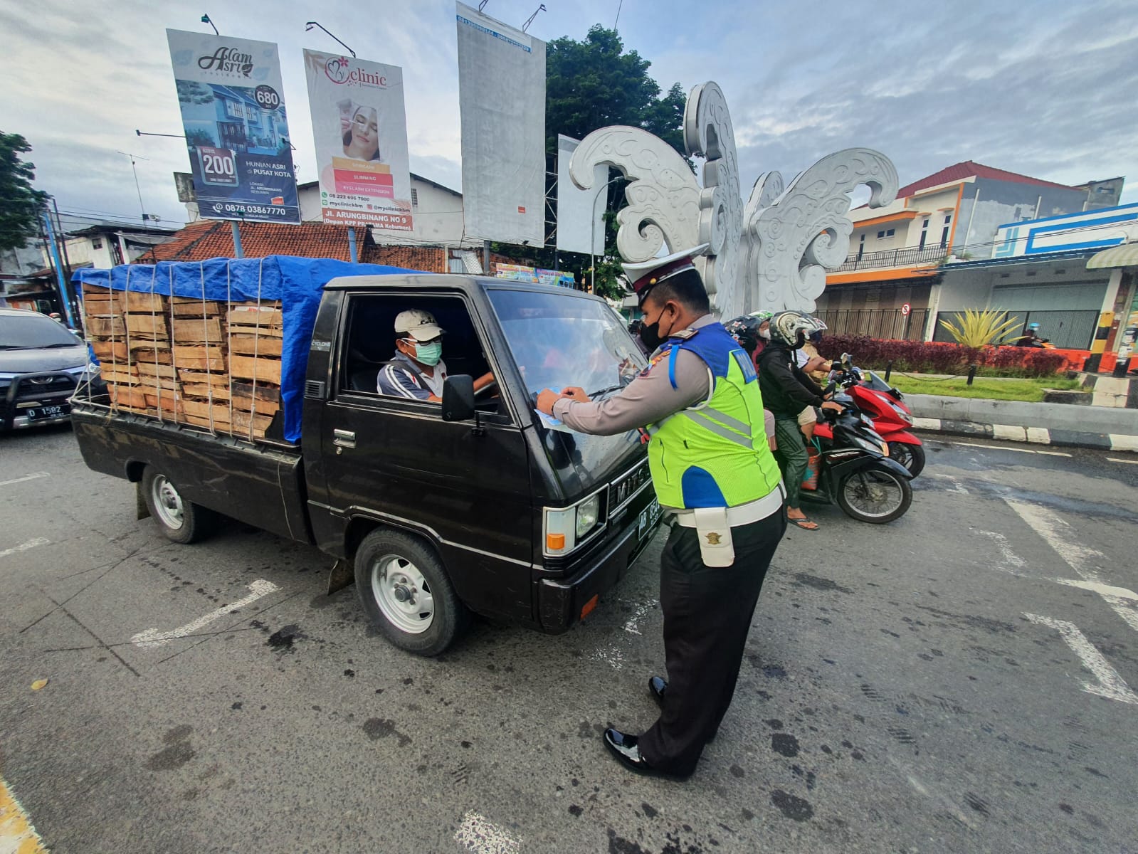 TAK TERTIB: Petugas Satlantas Polres Kebumen membagikan masker dan menempel stiker pada kegiatan Operasi Keselamatan Lalu Lintas Candi 2022.